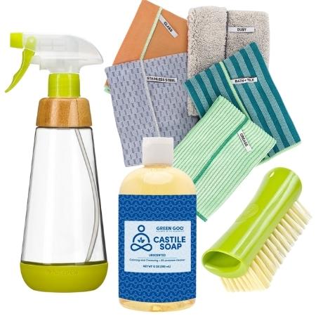 Set of eco-friendly cleaning products with upcycled materials including refillable spray bottle, natural castile soap, recycled scrub brush and cleaning cloth set.
