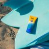 Reef-Safe sunscreen in 3oz travel size bottle from Sea & Summit on surfboard