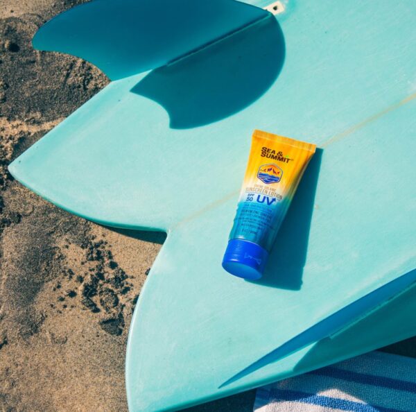 Reef-Safe sunscreen in 3oz travel size bottle from Sea & Summit on surfboard