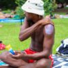 Man putting on reef-safe, non-toxic sunscreen in 3oz travel size for outdoor picnic