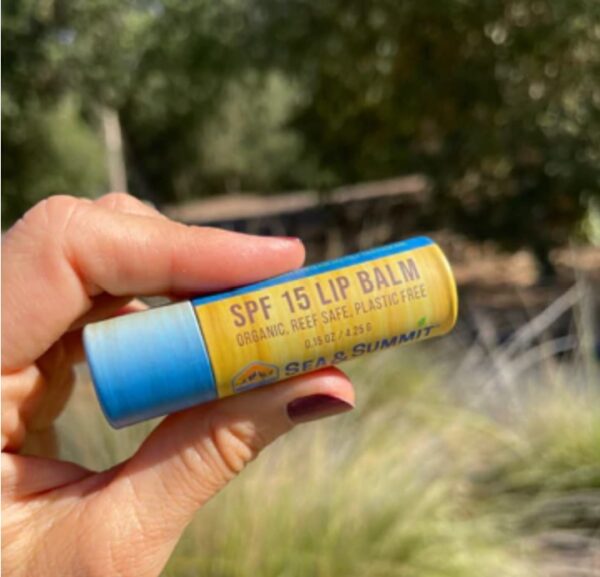 Hand holding SPF 15 organic lip balm from Sea & Summit