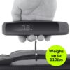 Hand holding digital luggage scale with suitcase.