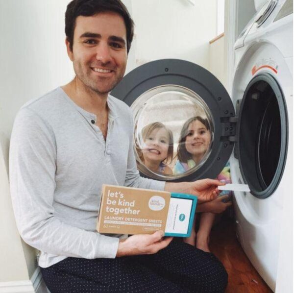 Man and two kids putting in sheet of zero-waste laundry detergent sheet into front load washer