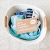 Box of low-waste, plant-based laundry detergent sheets on top of laundry in basket