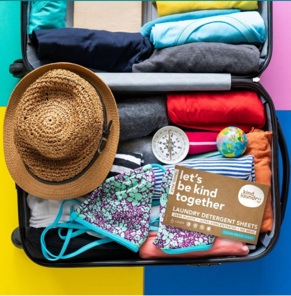 Travel pack of plastic-free laundry detergent sheets packed in a suitcase