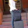 Model is shown arriving at her hotel with her stylish and earth-friendly Meridian luggage by Sherpani. Luggage is shown in black with Sherpani flower logo on the front.