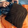 Eco-friendly camping with person using black stuffable travel pillowcase from Rumpl.