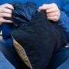 Person's hands stuffing Rumpl, recycled travel pillowcase in navy