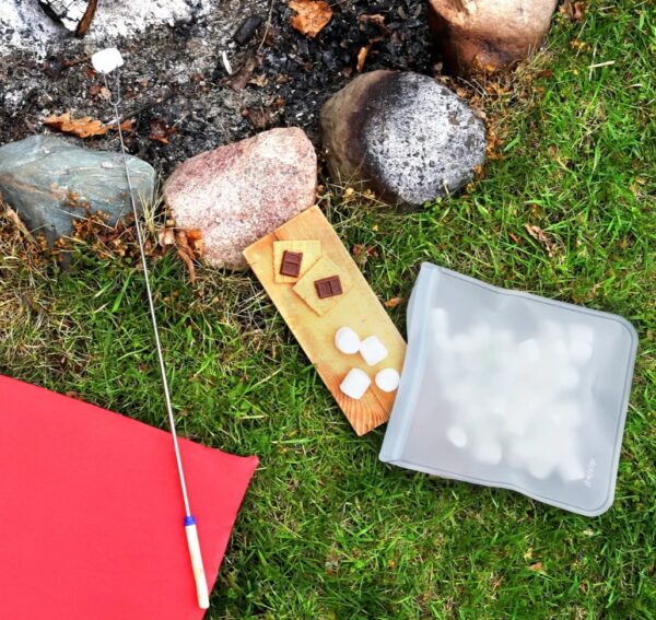 Outdoor photo of (re)zip reusable gallon bag with s'mores for sustainable travel and living.