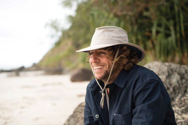 Man on beach in crushable, recycled boating and travel hat in khaki