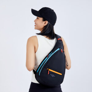 The 100% recycled Sherpani Esprit bag, made in Boulder, Colorado, is shown here in Chromatic. This sustainably made bag is all black and features brightly colored orange and blue zippers with highlighter red zipper pulls.