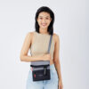 The Sherpani Pica crossbody bag, made from 100% recycled materials, is shown here in a colorblock with stone and black and bright red zipper pulls. It has a zippered fold-over pocket and includes a detachable keychain.