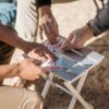 Playing cards outdoors on plastic-free Canyon aluminum travel side table