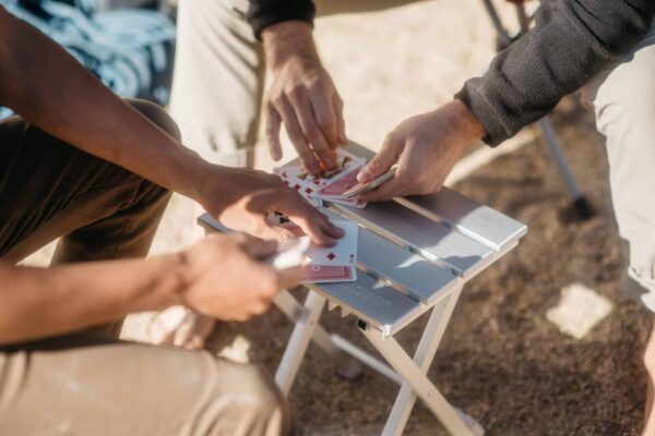 Playing cards outdoors on plastic-free Canyon aluminum travel side table
