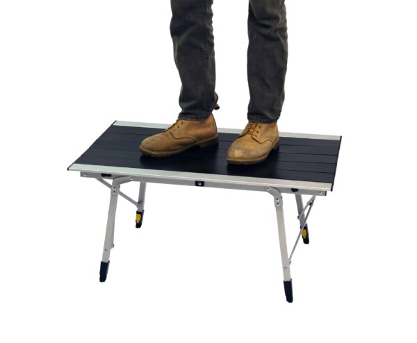 Man standing on lowest height of adjustable-heigh Grand Canyon outdoor travel table