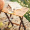 Glass of wine in foldable bamboo outdoor side table
