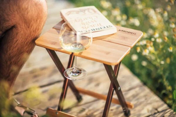Glass of wine in foldable bamboo outdoor side table