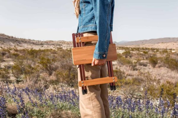 Person carrying foldable bamboo outdoor side table