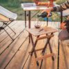 Person pouring wine on eco-friendly bamboo side table for backyard and camping