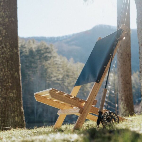 View of blue-backed, wood, USA-made travel chair with mountain