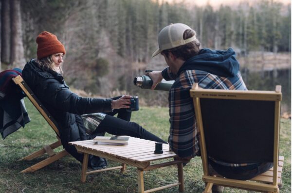 Couple outdoors with hand-crafted, portable wood furniture