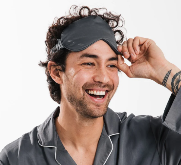 Man wearing sustainable travel eye mask