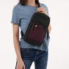 The Sherpani Metro Convertible Travel Sling is shown here in merlot by someone wearing it across their torso. It extends from their shoulder, across the front of their body, down to their waist.