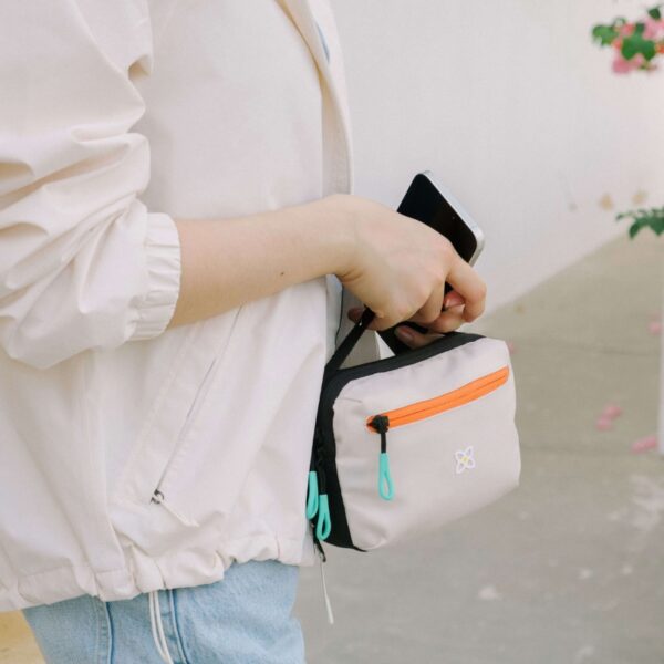 This image shows someone holding the Hyk Hip Pack by a top strap with their hand, not using the waist belt at all. It can be a convenient bag to just grab and go.