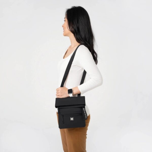 This shows someone carrying the Pica Mini Crossbody bag as a regular purse, over their shoulder.