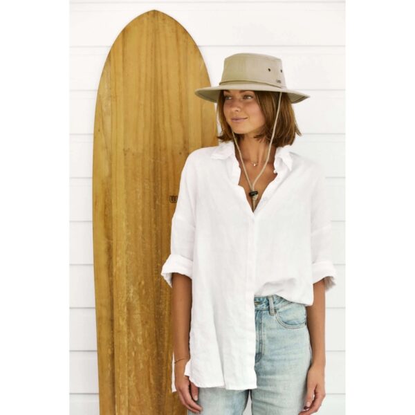 This shows a woman wearing the Aussie Surf Organic Cotton hat. It comes in one color, khaki. It's offered in 5 sizes: small, medium, large, x-large, xx-large. The wide brim offers great sun protection. The hat can get wet and dry naturally. It packs flat for travel.