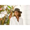 This shows a woman wearing the Dusty Road Aussie Waterproof Cotton Hat. It comes in one color, brown. It offers 50+ UPF protection. It's made with weathered cotton and comes in 5 sizes: small, medium, large, x-large, xx-large.