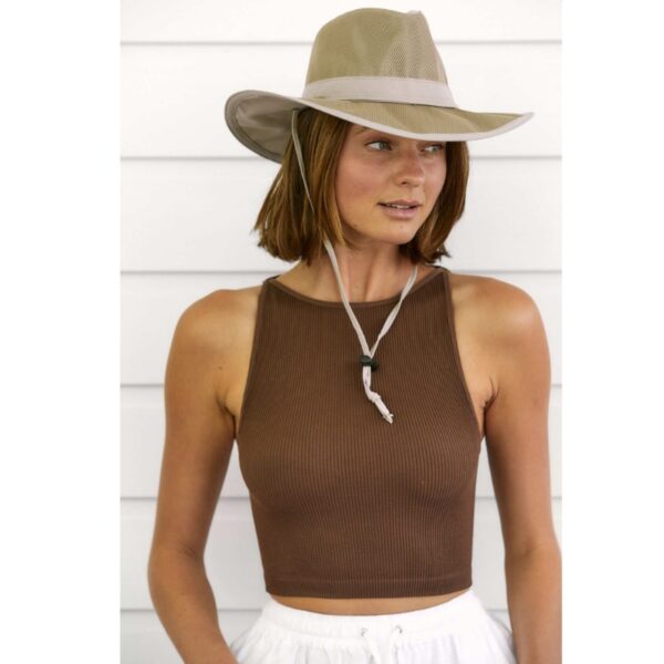 This shows a woman wearing the Sunblocker Lightweight Recycled Outdoor Hat. It comes in just one color, sand. It's offered in 5 sizes: small, medium, large, X-Large, XX-Large. It offers 50+ UPF protection and is waterproof. It also has an under-chin strap to keep it in place on windy days.